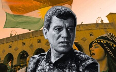 قائد قوات سوريا الديمقراطية مظلوم عبدي وعلى الخلفية مظاهرات في مدينة أربيل، عاصمة إقليم كوردستان