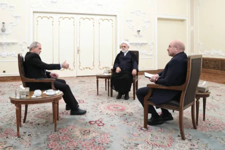 الرئيس الإيراني مسعود بزشكيان يتحدث لرئيس مجلس الشورى الإسلامي محمد باقر قاليباف ورئيس السلطة القضائية غلام حسين محسني إجئي